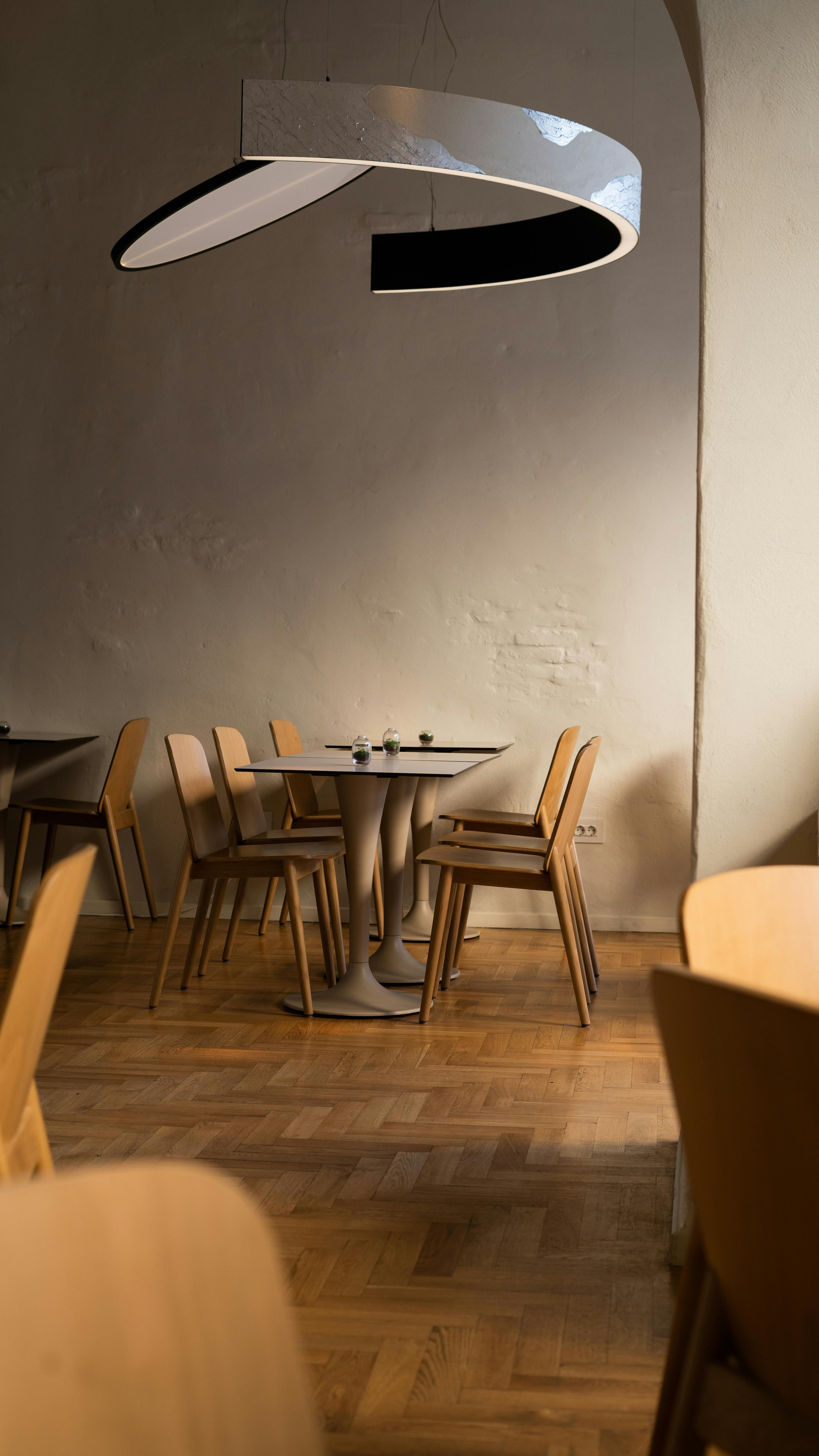 A moody restaurant interior with warm, sculptural lighting
